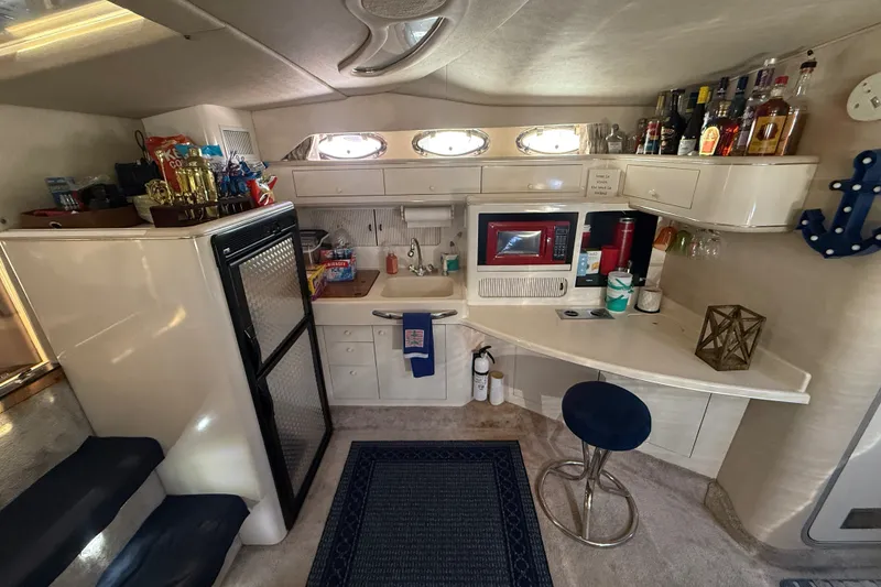 Slide: The Image of Interior of a 1996 Sea Ray 400 Express Cruiser with kitchenette and bar area. - 27