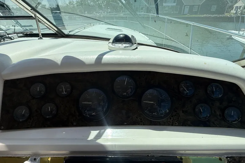 Slide: The Image of 1996 Sea Ray 400 Express Cruiser dashboard with gauges and compass, docked in a marina. - 20