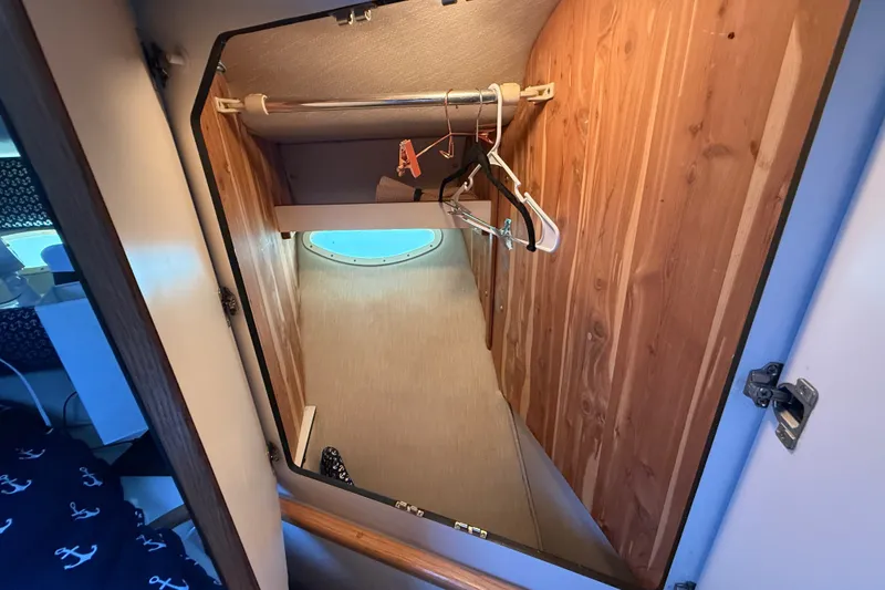 Slide: The Image of Interior closet of 1996 Sea Ray 400 Express Cruiser with wooden paneling and hangers. - 40