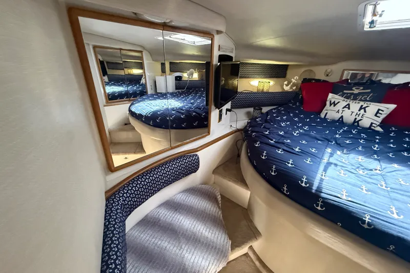 Slide: The Image of Interior of 1996 Sea Ray 400 Express Cruiser with nautical-themed bedding and mirrored walls. - 36