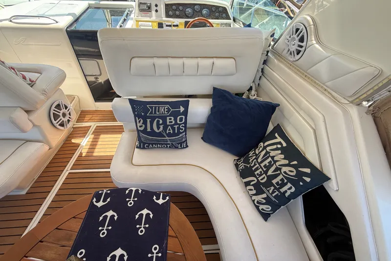 Slide: The Image of 1996 Sea Ray 400 Express Cruiser interior with nautical-themed cushions and wooden flooring. - 12