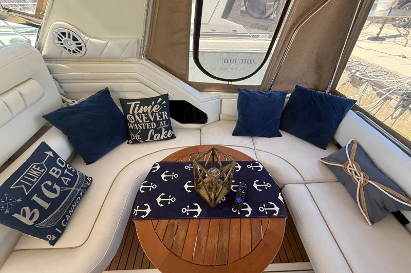 Slide: The Image of Interior of 1996 Sea Ray 400 Express Cruiser with nautical-themed decor and cushions. - 8