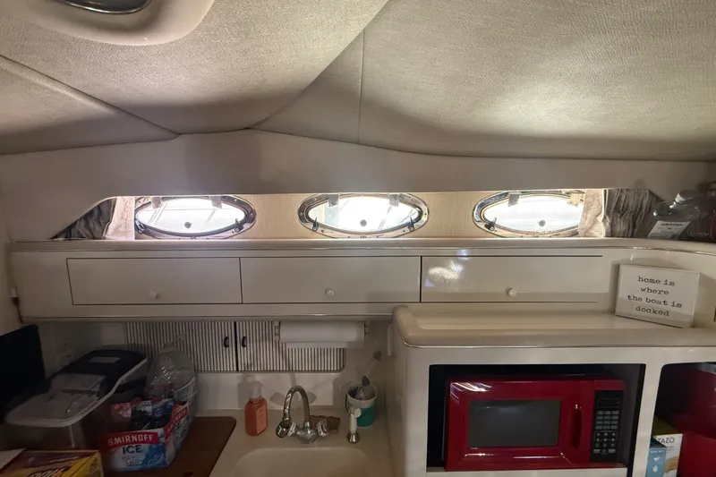 Slide: The Image of Interior of 1996 Sea Ray 400 Express Cruiser with kitchenette and porthole windows. - 29