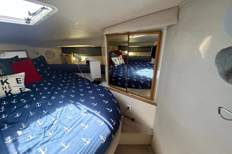 Slide: The Image of Cozy cabin interior of 1996 Sea Ray 400 Express Cruiser with nautical-themed bedding. - 37