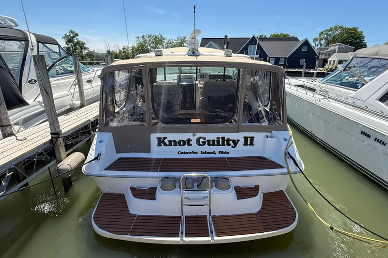 Slide: The Image of 1996 Sea Ray 400 Express Cruiser docked, named "Knot Guilty II," at Catawba Island, Ohio. - 1