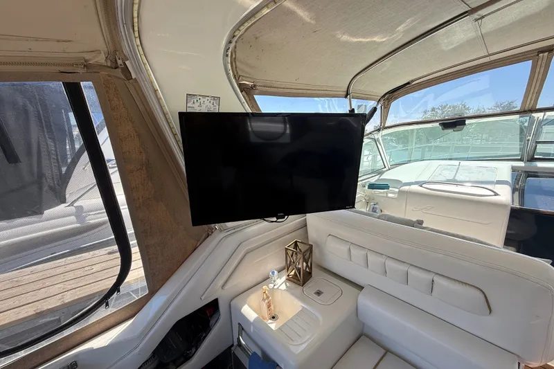 Slide: The Image of Interior of a 1996 Sea Ray 400 Express Cruiser with TV and white seating. - 16