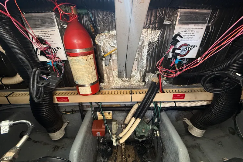 Slide: The Image of Engine room of a 1996 Sea Ray 400 Express Cruiser with wiring and fire extinguisher. - 46