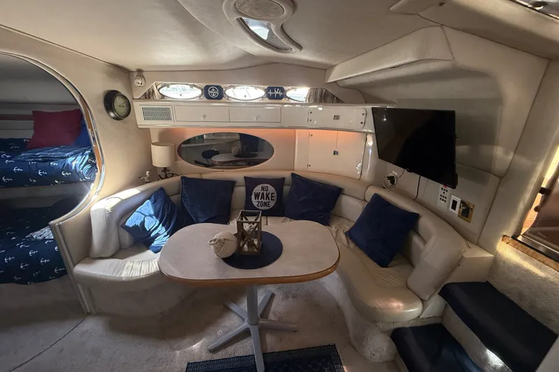 Slide: The Image of Interior of a 1996 Sea Ray 400 Express Cruiser with cozy seating and nautical decor. - 26