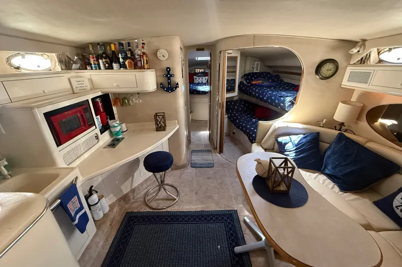 Slide: The Image of Interior of a 1996 Sea Ray 400 Express Cruiser with cozy seating and kitchenette. - 25