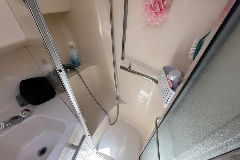 Slide: The Image of Shower area in 1996 Sea Ray 400 Express Cruiser with toiletries and showerhead. - 34