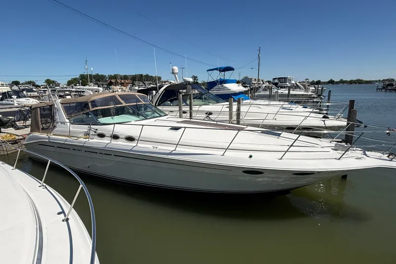 Slide: The Image of 1996 Sea Ray 400 Express Cruiser docked at a marina under clear blue skies. - 3