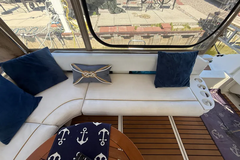 Slide: The Image of Interior of 1996 Sea Ray 400 Express Cruiser with white seating and nautical-themed decor. - 11