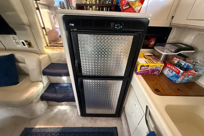 Slide: The Image of Interior of a 1996 Sea Ray 400 Express Cruiser with a compact kitchen area. - 28