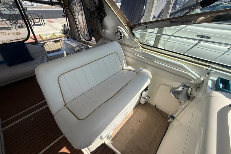 Slide: The Image of Interior of 1996 Sea Ray 400 Express Cruiser with white seating and wooden flooring. - 24