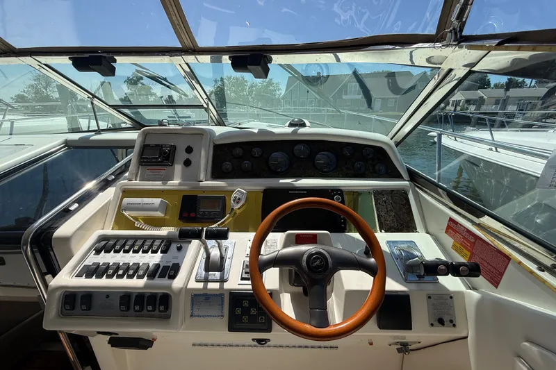 Slide: The Image of 1996 Sea Ray 400 Express Cruiser helm with steering wheel and control panel. - 19