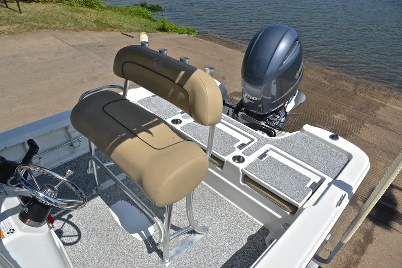 Slide: The Image of 2019 NauticStar 215 XTS Shallow Bay boat interior with seating and motor. - 22