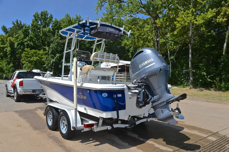 Slide: The Image of 2019 NauticStar 215 XTS Shallow Bay boat on trailer, Yamaha engine, parked outdoors. - 12