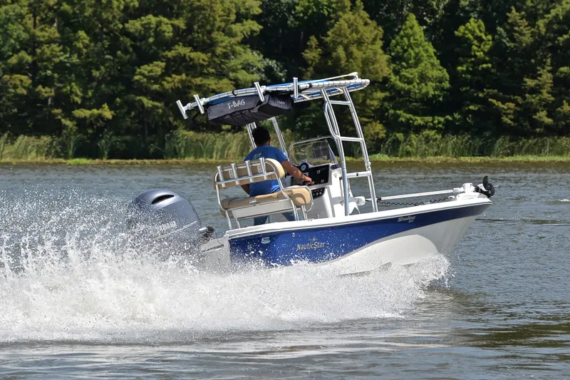 Slide: The Image of 2019 NauticStar 215 XTS Shallow Bay boat cruising on a scenic lake. - 5