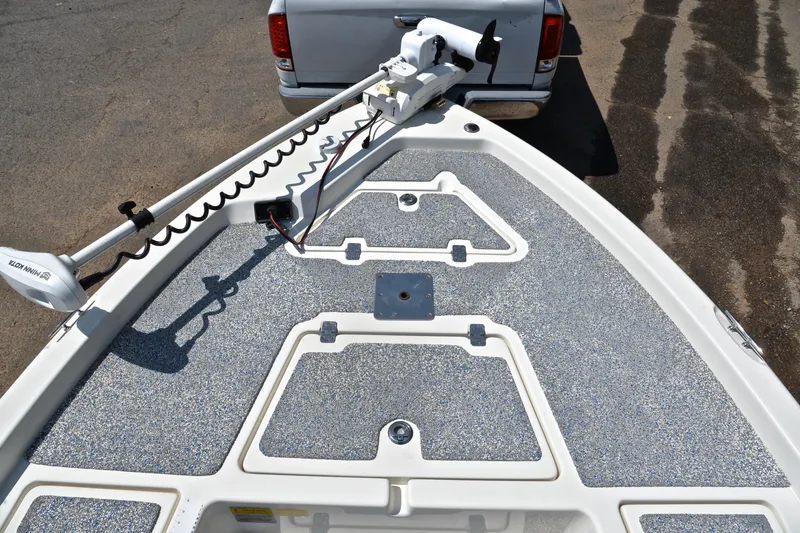 Slide: The Image of 2019 NauticStar 215 XTS Shallow Bay boat deck with trolling motor, parked on trailer. - 20