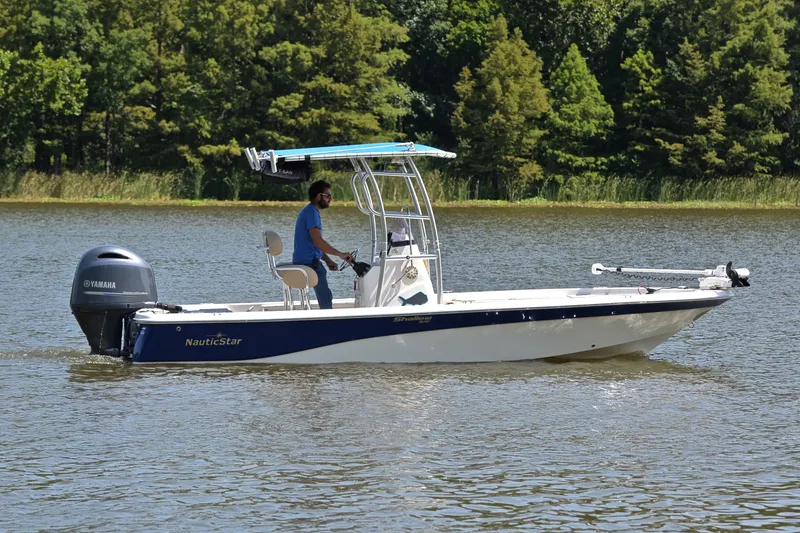 Slide: The Image of 2019 NauticStar 215 XTS Shallow Bay boat cruising on a serene lake. - 7