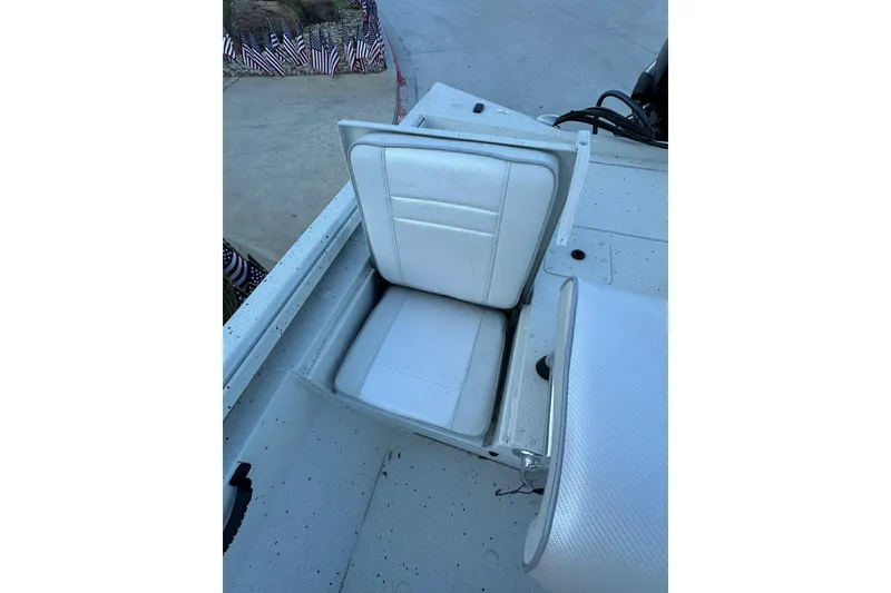 Slide: The Image of 2024 Ranger RB190 Bay boat seat with white upholstery, open storage compartment. - 16