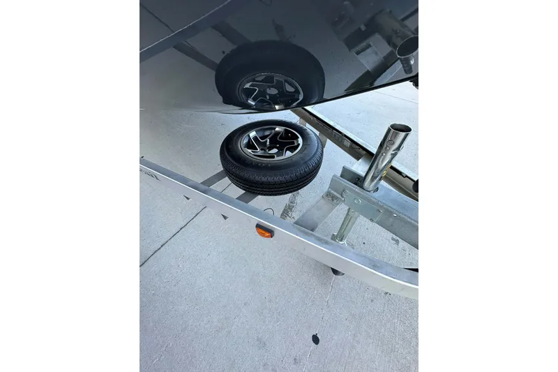 Slide: The Image of 2024 Ranger RB190 Bay boat trailer with spare tire on concrete surface. - 5