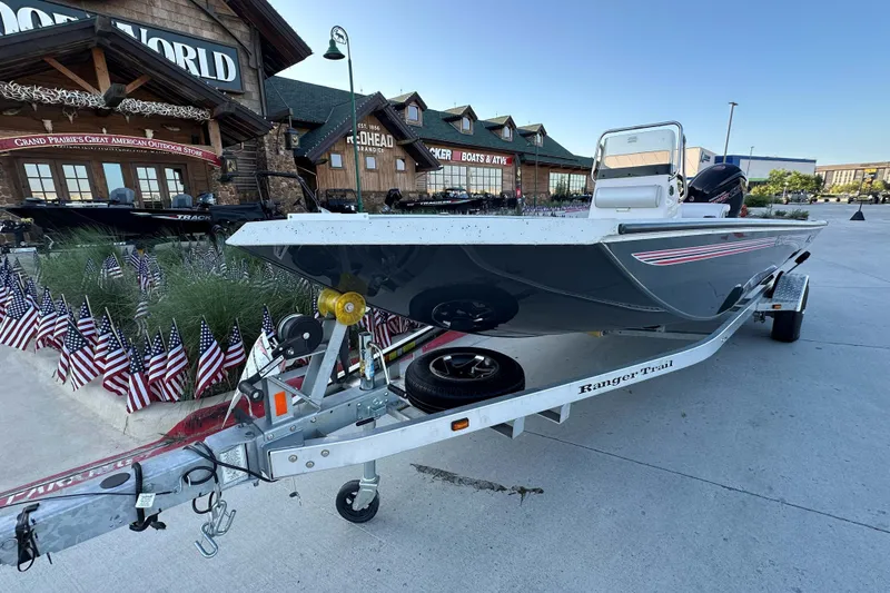 Slide: The Image of 2024 Ranger RB190 Bay boat on trailer outside outdoor store, surrounded by American flags. - 3