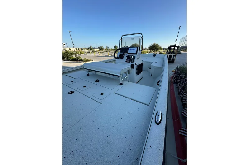 Slide: The Image of 2024 Ranger RB190 Bay boat interior with console and seating, parked outdoors. - 9