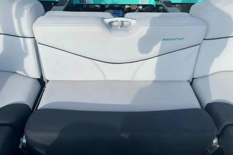 Slide: The Image of 2018 MasterCraft XT23 boat interior seating with white and black upholstery. - 17