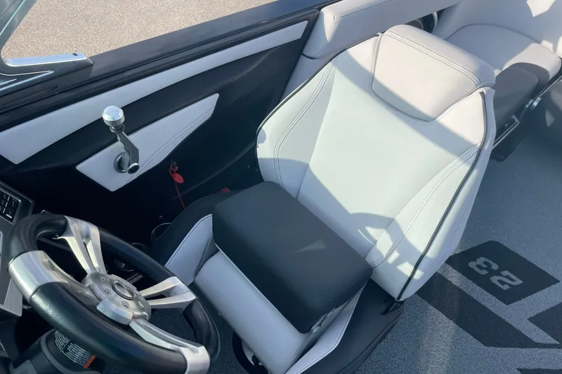 Slide: The Image of 2018 MasterCraft XT23 boat interior with steering wheel and captain's seat. - 19