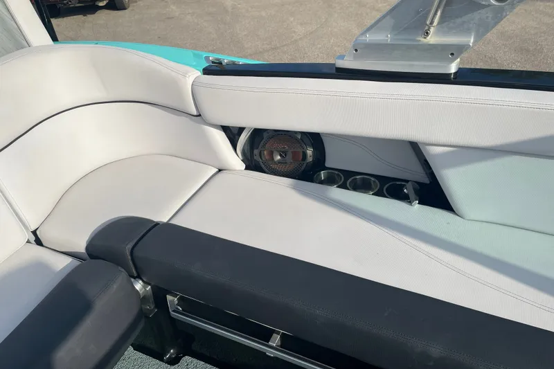 Slide: The Image of 2018 MasterCraft XT23 boat interior with white seating and built-in speaker. - 16