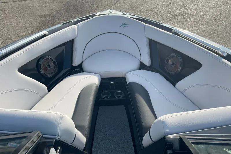 Slide: The Image of 2018 MasterCraft XT23 boat interior with white and black seating, featuring built-in speakers. - 10