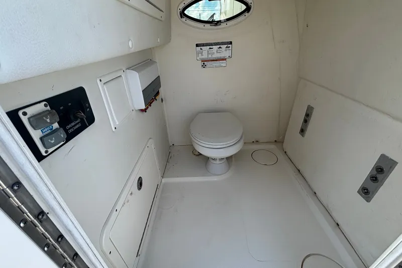 Slide: The Image of Interior of 2021 World Cat 295 CC boat bathroom with toilet and control panel. - 14