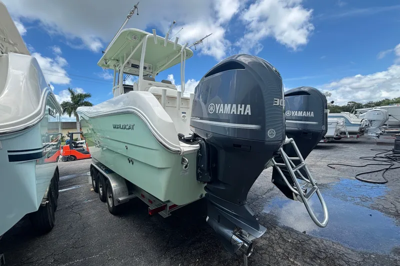 Slide: The Image of 2021 World Cat 295 CC boat with dual Yamaha engines, parked outdoors under a blue sky. - 3