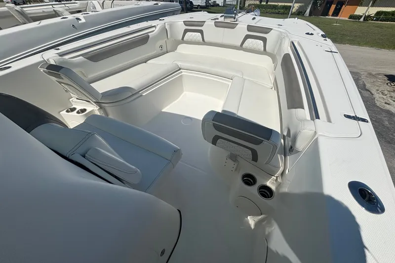 Slide: The Image of 2021 World Cat 295 CC boat interior with white seating and cup holders. - 15