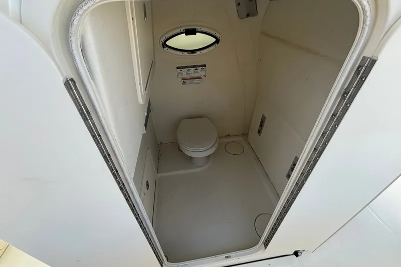 Slide: The Image of 2021 World Cat 295 CC boat interior with compact marine toilet and porthole. - 13