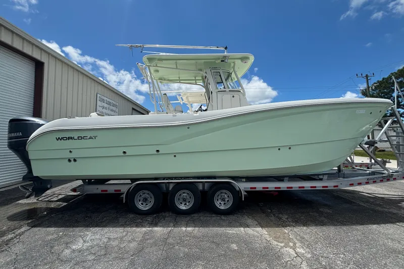 The Image of 2021 World Cat 295 CC boat on trailer, parked outdoors under a clear blue sky. - 0