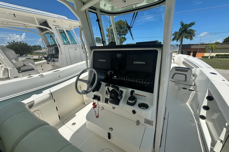 Slide: The Image of 2021 World Cat 295 CC boat cockpit with Garmin navigation system and steering wheel. - 6