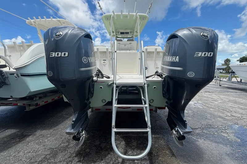 Slide: The Image of 2021 World Cat 295 CC boat with dual Yamaha 300 engines, parked outdoors. - 2
