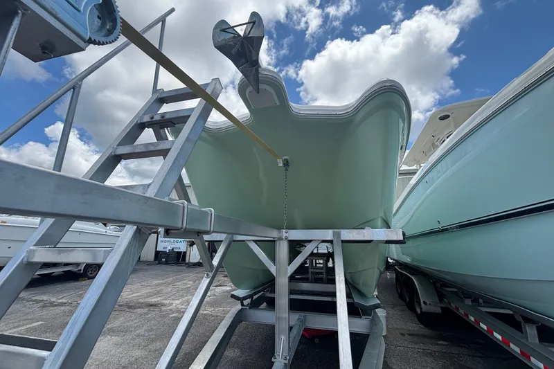 Slide: The Image of 2021 World Cat 295 CC boat on trailer under cloudy sky. - 24