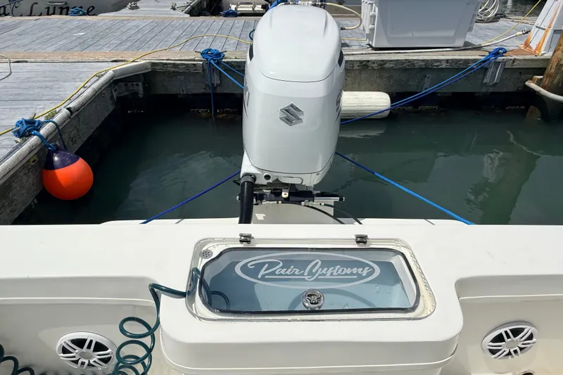 Slide: The Image of 2023 Pair Customs 24 Center Console DV boat with Suzuki outboard motor at dock. - 11