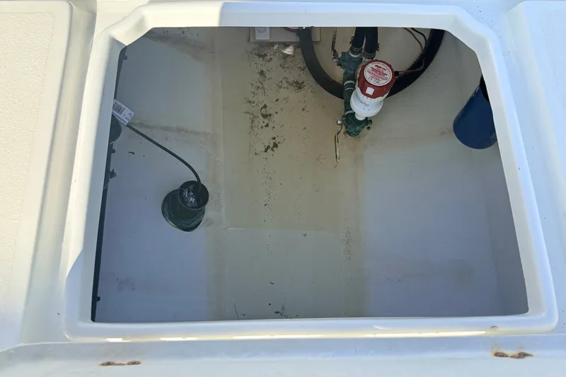 Slide: The Image of 2023 Pair Customs 24 Center Console DV boat compartment with visible wiring and components. - 16