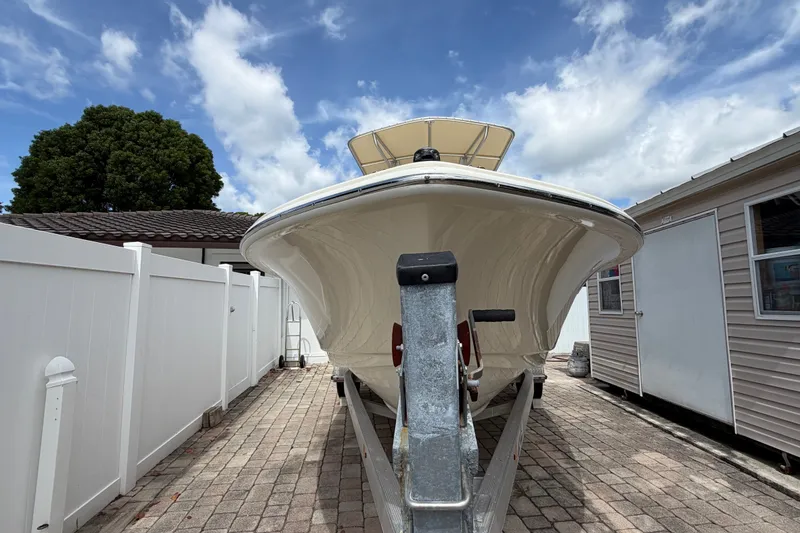 Slide: The Image of 2017 Scout 195 Sportfish boat on trailer, parked in a driveway under a blue sky. - 3