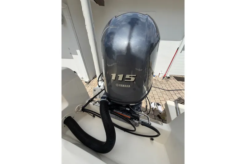 Slide: The Image of 2017 Scout 195 Sportfish with Yamaha 115 outboard motor, parked on a paved surface. - 24