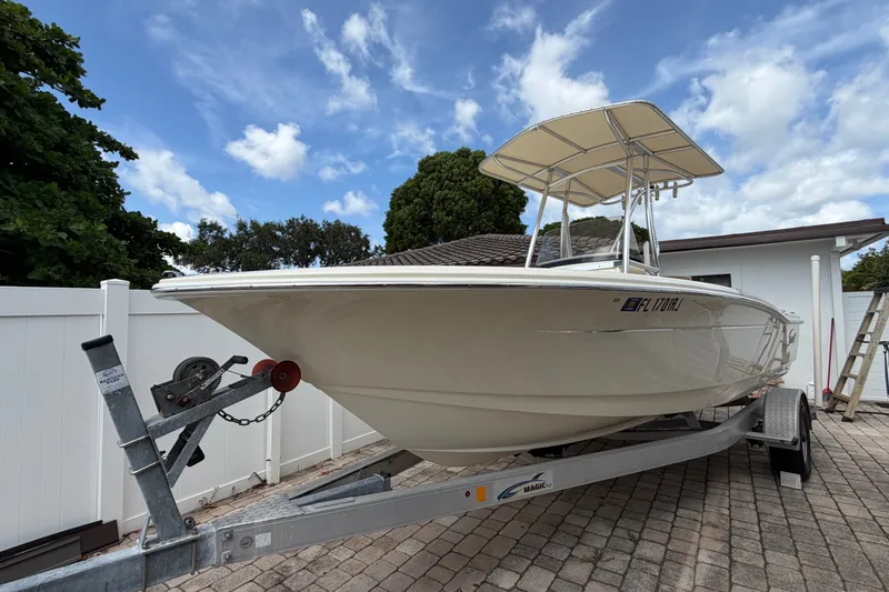 The Image of 2017 Scout 195 Sportfish boat on trailer, parked outdoors under a blue sky. - 1