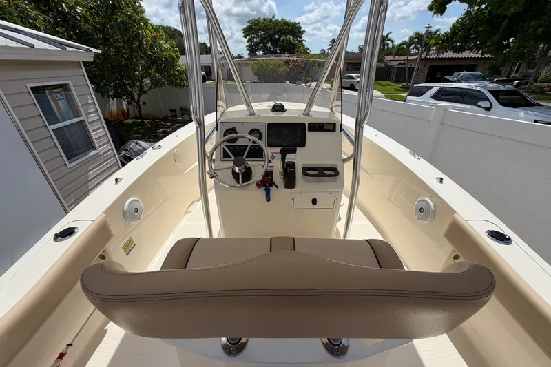 Slide: The Image of 2017 Scout 195 Sportfish boat interior with steering console and seating in a residential setting. - 10