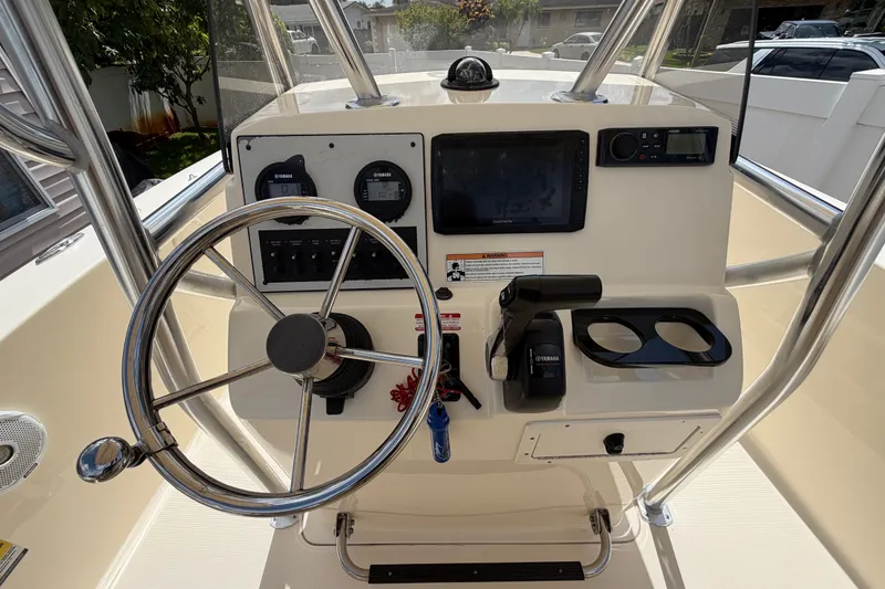 Slide: The Image of 2017 Scout 195 Sportfish boat dashboard with steering wheel and navigation controls. - 11