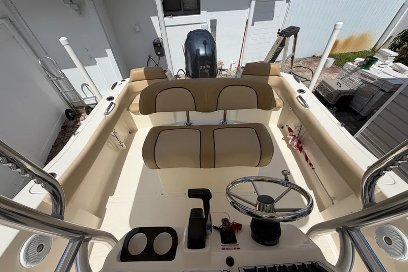 Slide: The Image of 2017 Scout 195 Sportfish boat interior with beige seating and steering wheel. - 20