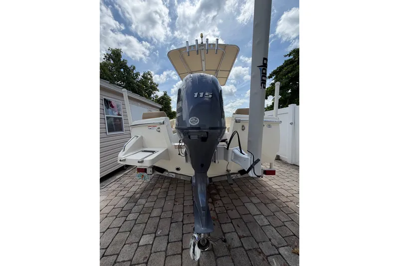 Slide: The Image of 2017 Scout 195 Sportfish boat with outboard motor on paved driveway. - 6
