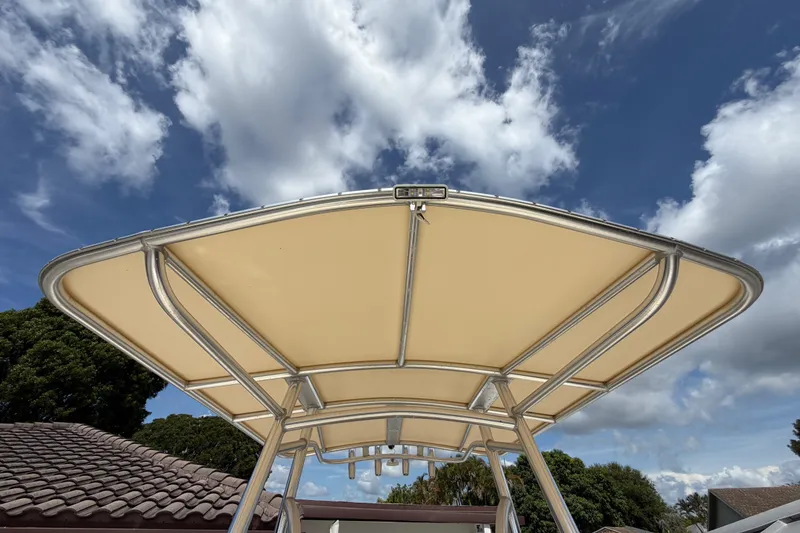 Slide: The Image of 2017 Scout 195 Sportfish boat canopy against a partly cloudy sky. - 21